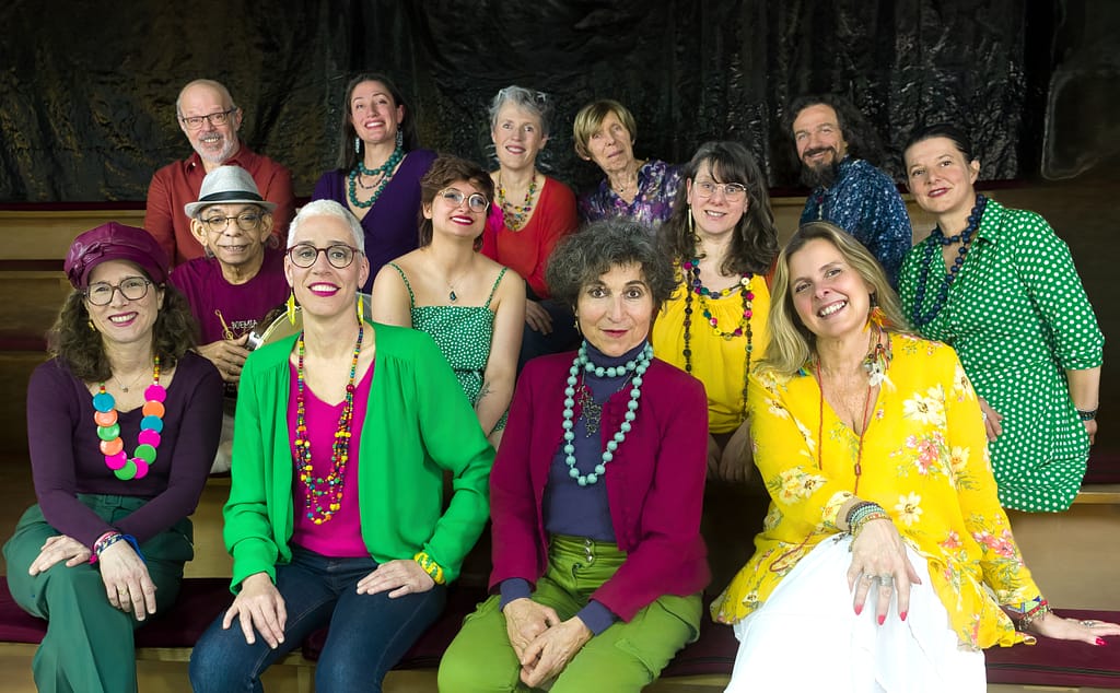 Le groupe Espace Tempo assis en gradin, tenues colorées – Raphaelle Bois